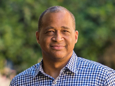 Photo of a Black male faculty member smiling.