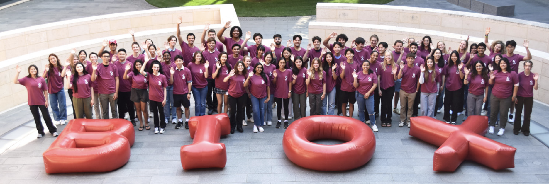 76 undergraduate students outdoors, wearing matching red T-shirts with white Bio-X logo.