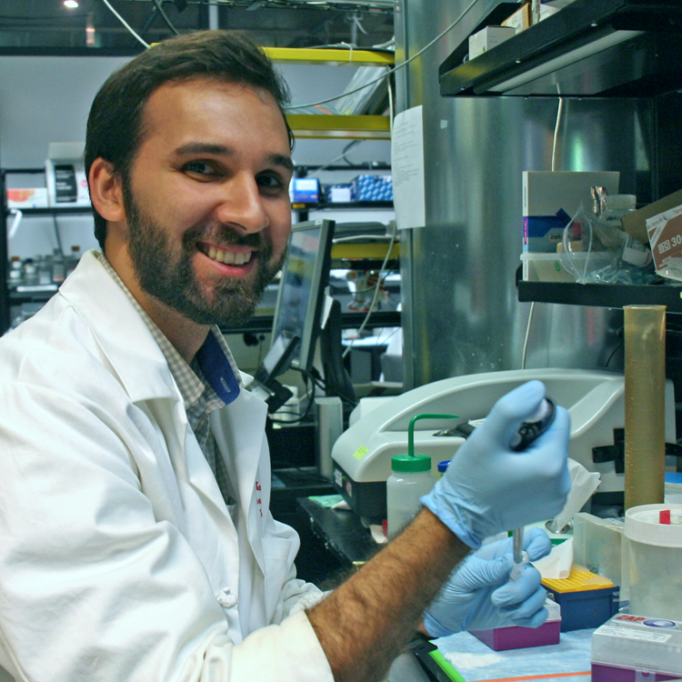 Photo of graduate student Amin Aalipour in the lab, using a pipette.