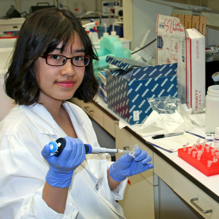 Photo of USRP student Ellen Ouyang in the laboratory, working with a pipette.