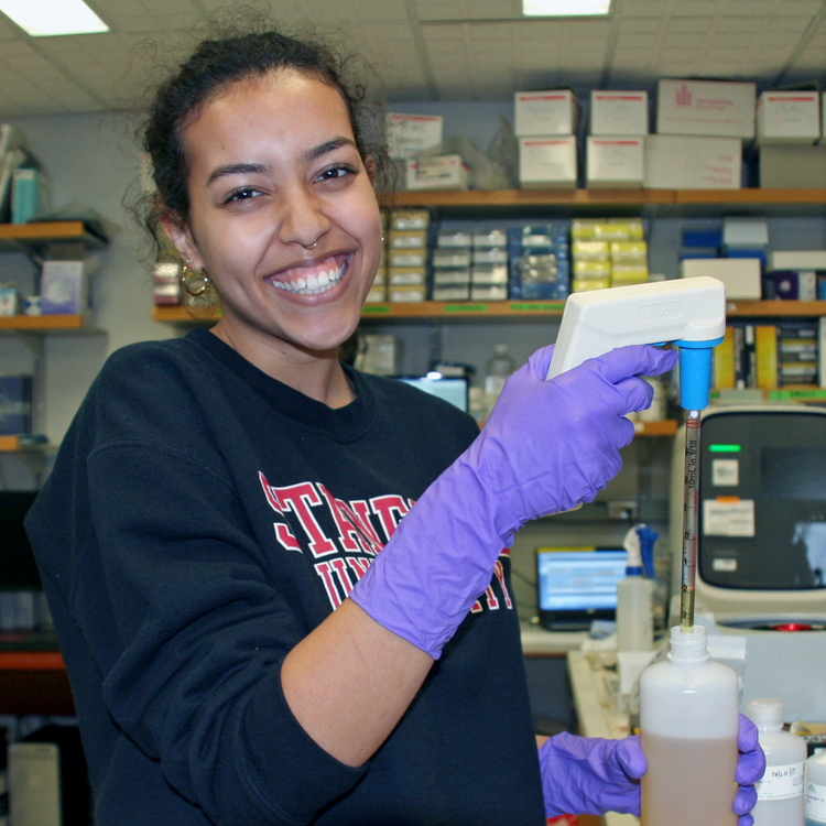Photo of USRP student Ginger Gramson in the laboratory, working with a pipetter.
