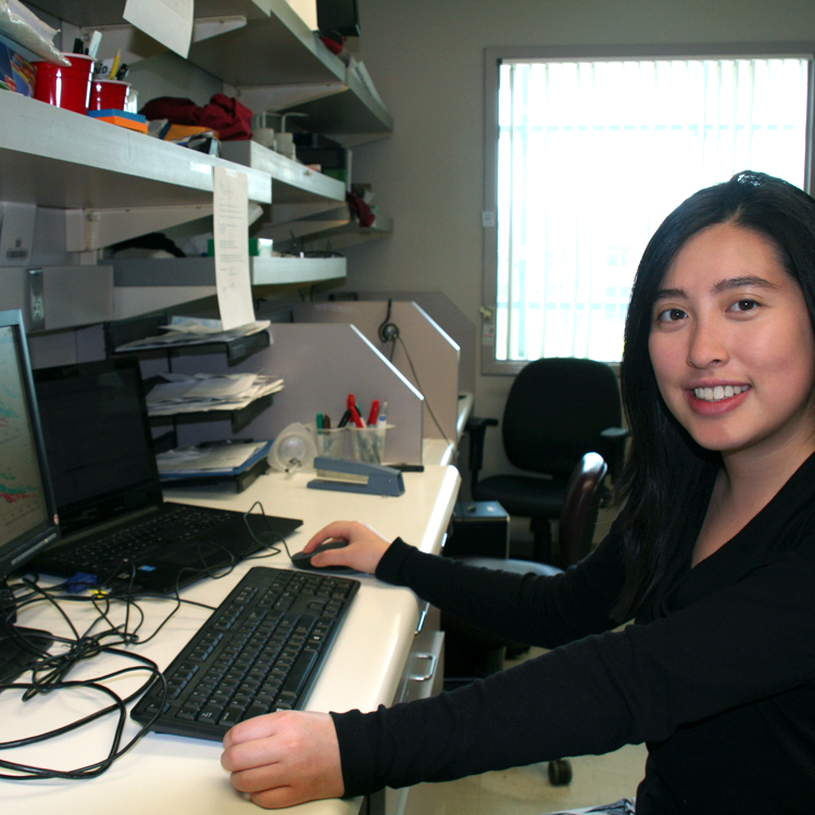 Photo of USRP student Grace Ng in the lab, working at a laptop computer.