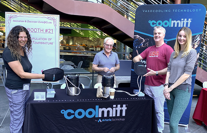Outdoor photo of Dr. Craig Heller, Dr. Ayelet Voskoboynik, and associates presenting the Cold Mitt booth.