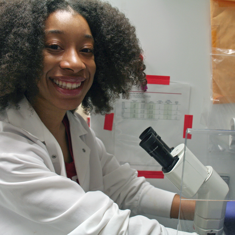Photo of USRP student Kamina Wilkerson in the lab, using a microscope.