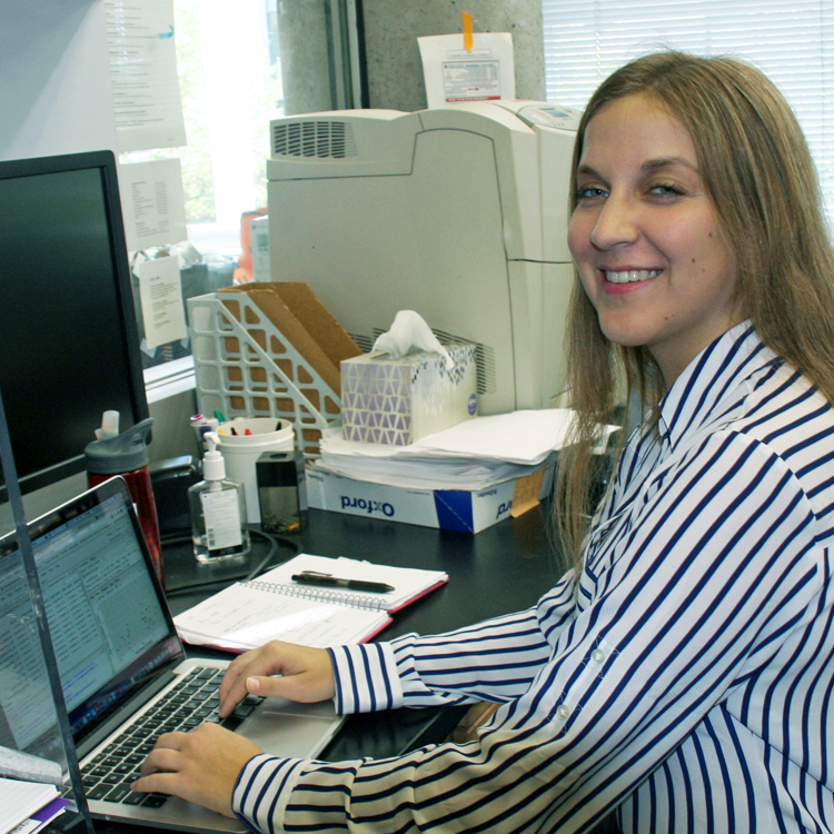 Photo of graduate student Kelly McGill in the lab, working on a computer.