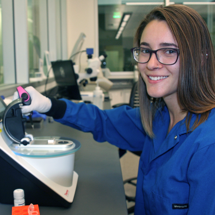 Photo of graduate student Margarita Khariton in the lab, using a small machine and a pipette.