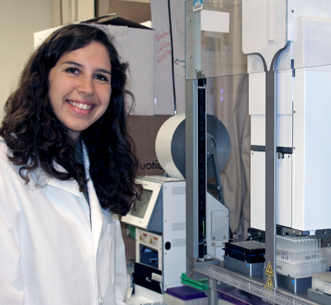 Photo of smiling female graduate student in a wet laboratory.