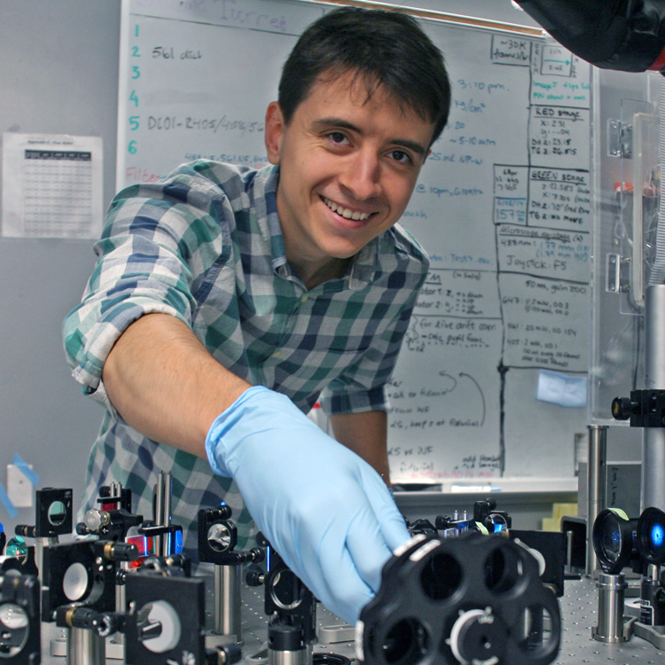 Photo of graduate student Petar Petrov in the lab, operating a laser system.