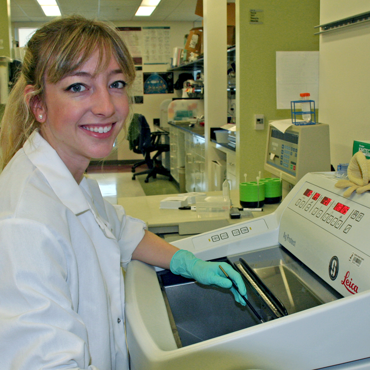 Photo of graduate student Rebecca Marton in the lab, using a Leica machine.