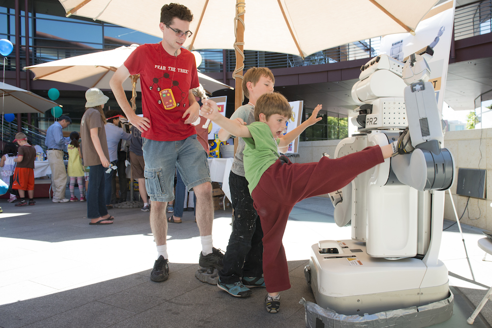 Kids interact with the PS2 personal robot.