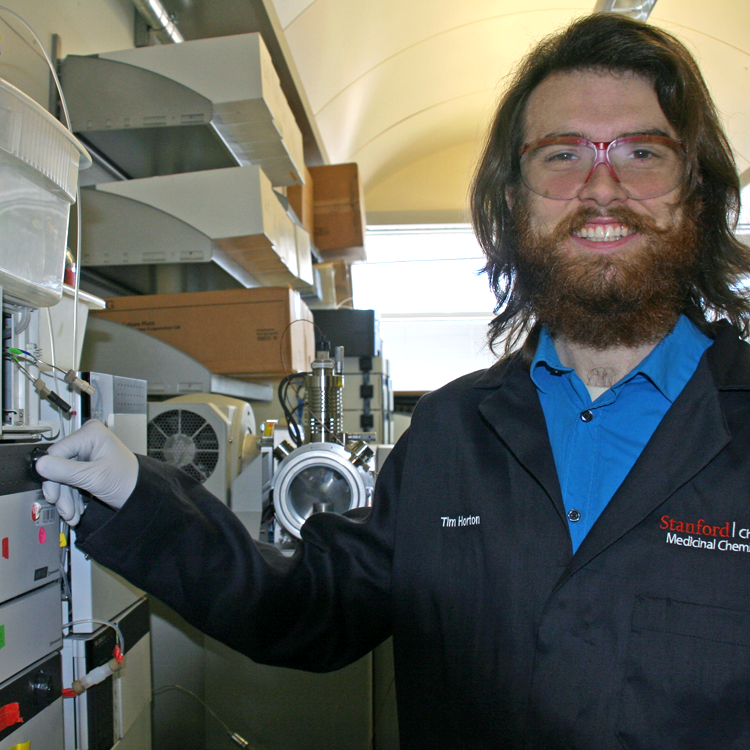 Photo of graduate student Timothy Horton in the lab, using a standing machine.