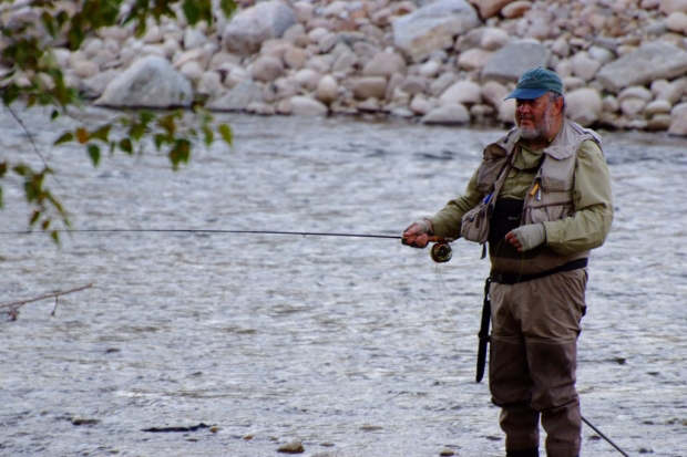 Photo of Dr. Weissman fly-fishing.