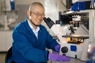 Indoor photo of an Asian male faculty member working in a wet lab.