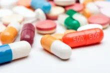 Photo of an assortment of colorful pills spilled across a white surface.