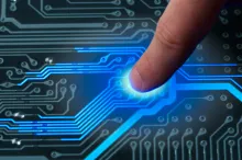Graphic image of a fingertip being pressed to a circuit board, with circuits lighting up blue.