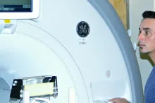 Photo of Professor Kalanit Grill-Spector, research associate Kevin Weiner, and graduate student Jesse Gomez next to MRI machine.