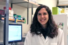 Photo of smiling female graduate student in a wet laboratory.