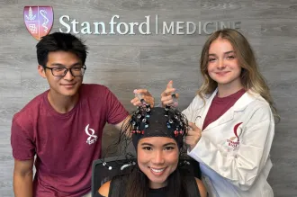 Collage of two indoor photos: left image shows a male Asian undergraduate and a Caucasian female undergraduate leaning in towards a female Asian postdoc wearing a helmet-shaped headgear piece with electrodes, all smiling at the camera. Second photo shows a Black male undergraduate pipetting at a lab bench, in profile to the camera.