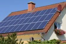 Photo of a house with numerous solar panels on the roof.