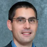 Indoor headshot photo of a male faculty member with glasses, Dr. Alfredo Dubra, Professor of Ophthalmology at Stanford University.