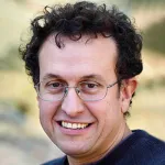 Outdoor headshot photo of a smiling white male faculty member, Dr. Andrea Montanari, Professor of Statistics and Mathematics at Stanford University.