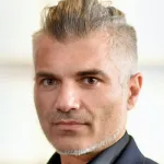 Indoor headshot photo of a white male faculty member with an undercut, Dr. Andreas Tolias, Professor of Ophthalmology at Stanford University.