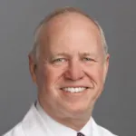 Indoor headshot photo of a smiling white male faculty member, Dr. William Berquist, Professor Emeritus of Pediatrics at Stanford University.