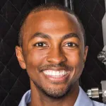 Photo of a smiling Black male faculty member, Dr. Christopher O. Barnes, Assistant Professor of Biology at Stanford University.