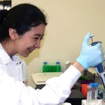 Indoor photo of an Asian female graduate student in a wet lab.