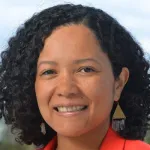 Outdoor headshot photo of a smiling Black female faculty member, Dr. Debbie Senesky, Associate Professor of Aeronautics & Astronautics and Electrical Engineering at Stanford University.