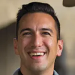 Photo of a smiling male faculty member with short dark hair, Dr. Jamil Zaki, Associate Professor of Psychology at Stanford University.