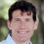 Outdoor headshot photo of a smiling white male faculty member, Dr. Lanier Benkard, The Gregor G. Peterson Professor of Economics at Stanford University.