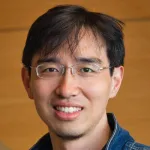 Headshot photo of a smiling Asian male faculty member with glasses, Dr. Le Cong, Assistant Professor of Pathology and Genetics at Stanford University.