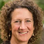 Photo of smiling white female faculty member with short curly brown hair, Dr. Lisa Orloff, Professor of Otolaryngology at Stanford University.