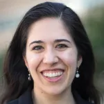 Headshot photo of smiling white female faculty member with long dark hair, Dr. Madeleine Udell, Assistant Professor of Management Science & Engineering at Stanford University.