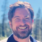 Outdoor headshot photo of a smiling white male faculty member, Dr. Sean Quirin, Assistant Professor of Psychiatry & Behavioral Sciences at Stanford University.