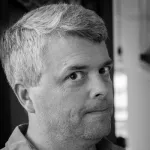 Black and white indoor headshot photo of a white male faculty member, Dr. Tom Wandless, Professor of Chemical and Systems Biology at Stanford University.