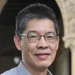 Outdoor headshot photo of a smiling male Asian faculty member, Dr. Wing Wong, Professor of Statistics at Stanford University.