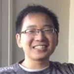 Indoor headshot photo of a smiling male Asian faculty member with glasses, Dr. Xiaojie Qiu, Assistant Professor of Genetics at Stanford.