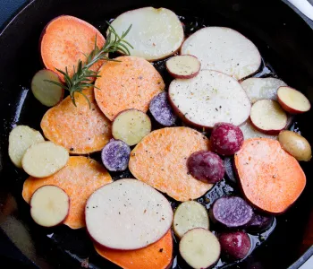 Photo of colorful potatoes being cooked in a pan.