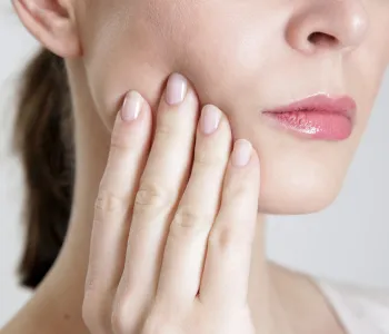 Stock photo of a woman touching her cheek.