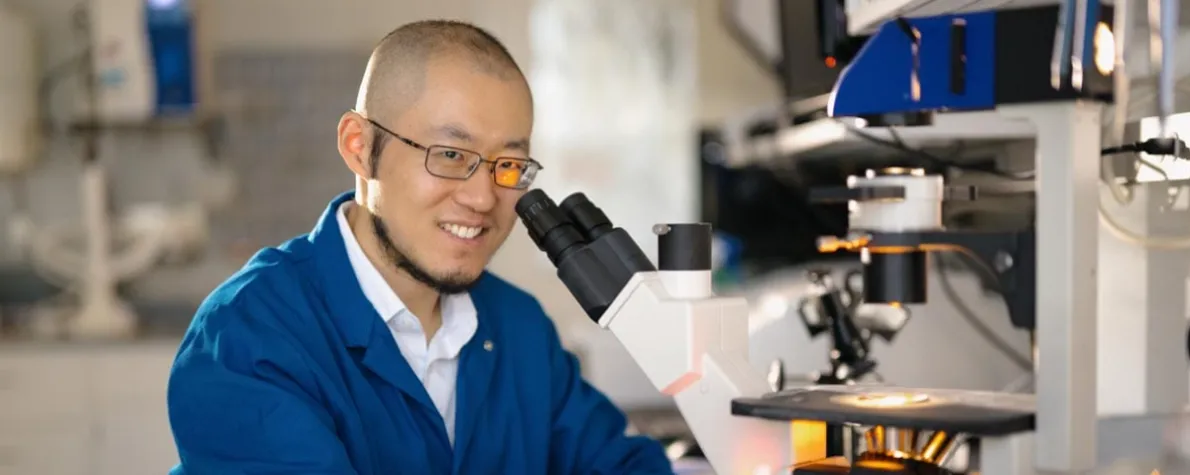 Indoor photo of an Asian male faculty member working in a wet lab.