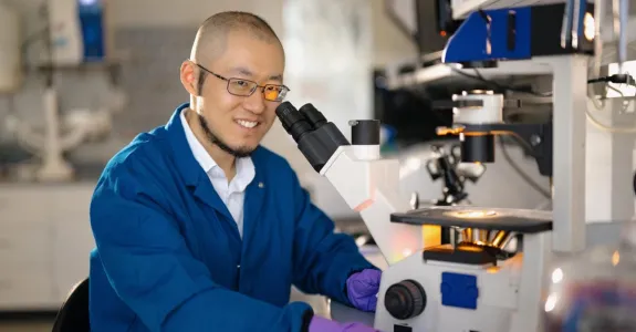 Indoor photo of an Asian male faculty member working in a wet lab.