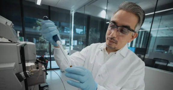 Photo of male faculty member in the laboratory with a pipette.