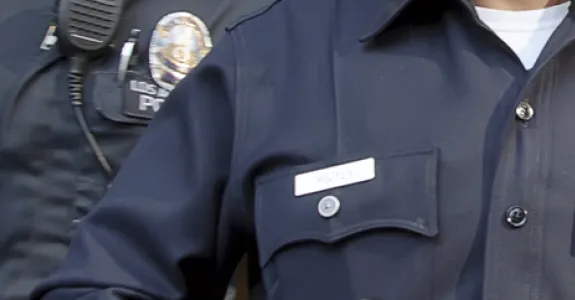 Photo of two police officers, showing the badges and name pins on their uniforms.