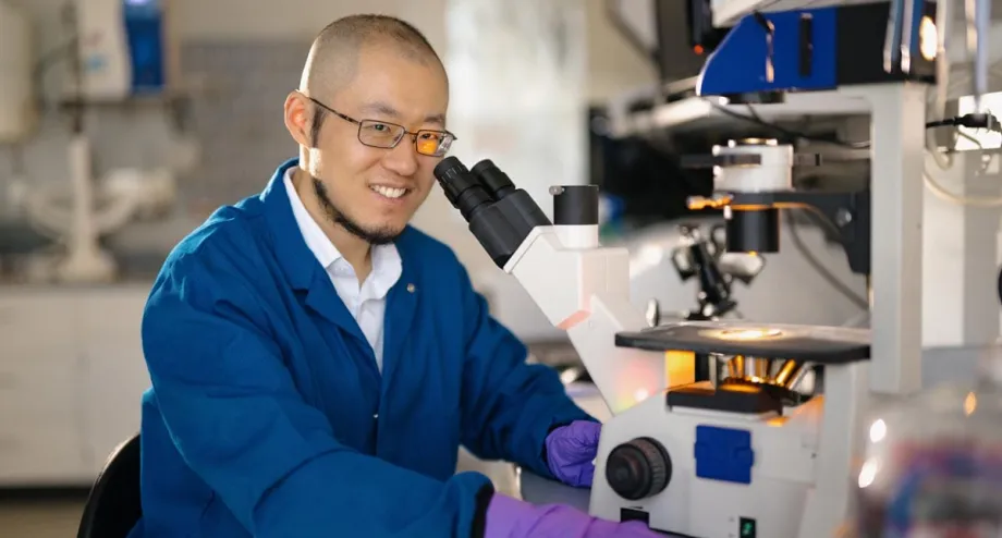Indoor photo of an Asian male faculty member working in a wet lab.