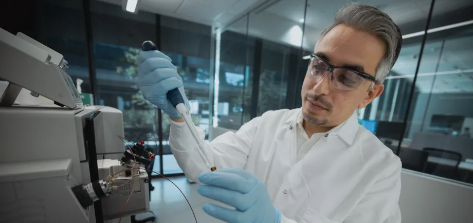 Photo of male faculty member in the laboratory with a pipette.