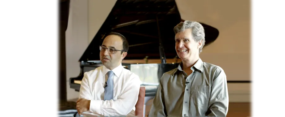 Photo of Drs. Josef Parvizi and Chris Chafe, previous Seed Grant recipients, seated side-by-side in front of a piano.