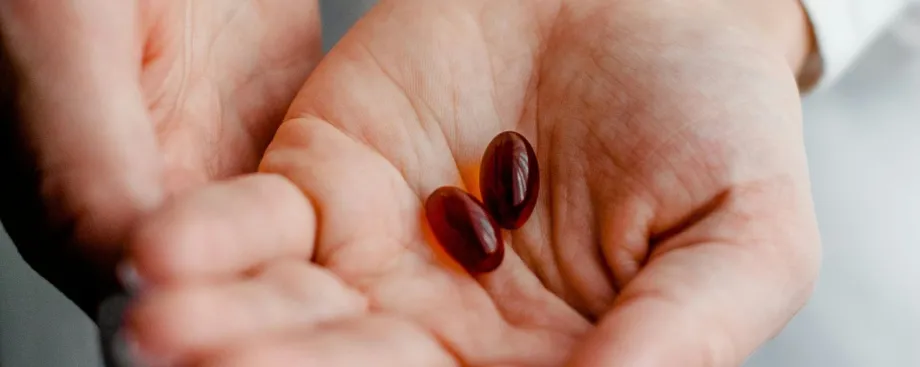 Photo of cupped hands with two large orange-brown pills held in the palms.