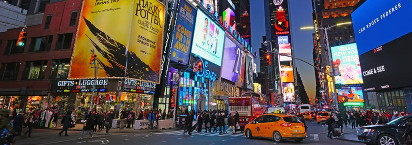 Photo of busy New York City intersection at night.